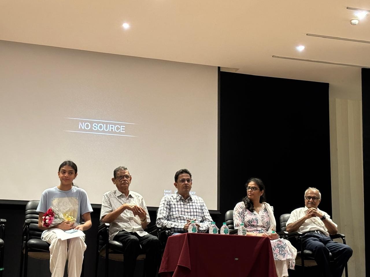 Panel discussion on stage at a school auditorium in India